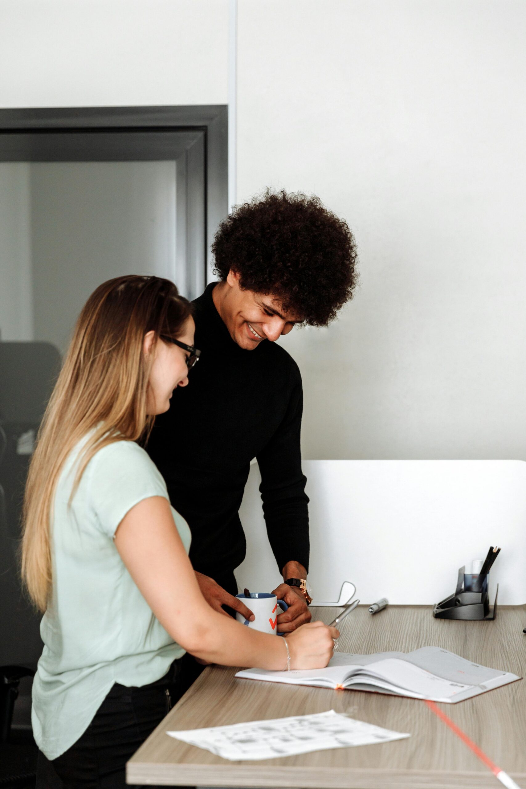 Two young professionals collaborating on a project in an office setting.